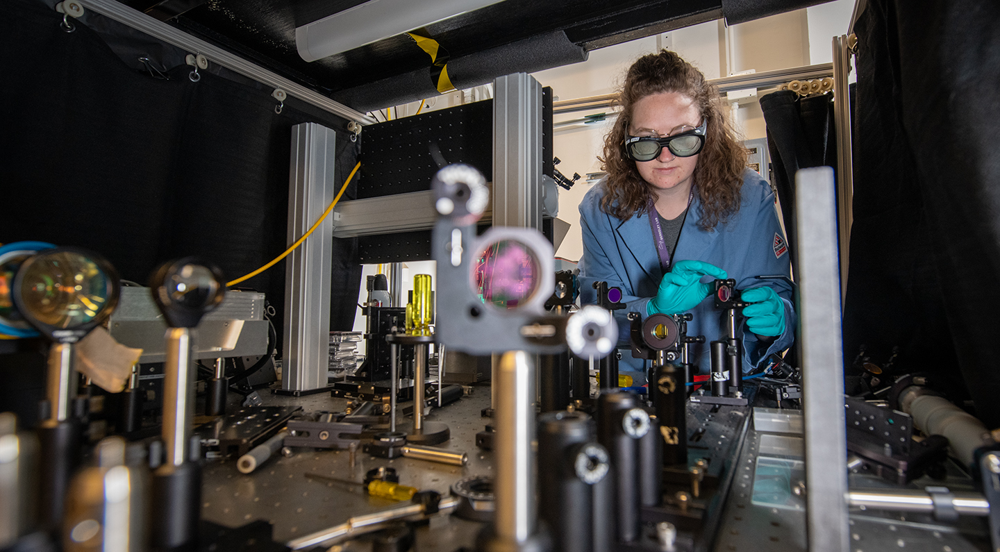 researcher adjusts scientific lens at Berkeley Lab