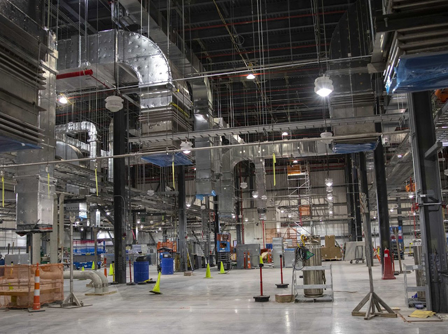 Interior view of warehouse with scientific equipment and overhead exhaust system